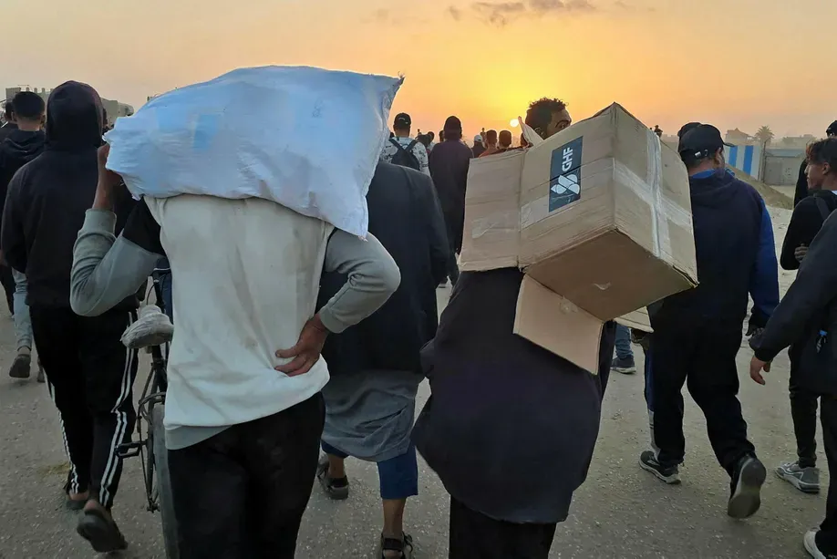 Ein Jugendlicher trägt am Sonntag eine leere Kiste mit Hilfsgütern der Gaza Humanitarian Foundation (GHF). Credit: AFP